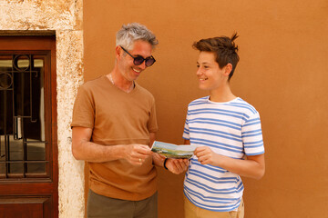 A father and son on a sightseeing trip in Rovinj, Croatia. . They are holding a map. Both appear...