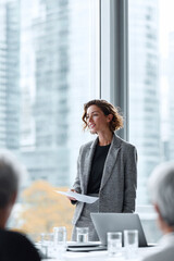 Confident woman presenting in modern office. Leadership, success, and corporate environments. Use for business, presentations, meetings, and career themes.