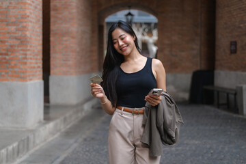 Young Asian businesswoman using smartphone and credit card for online shopping