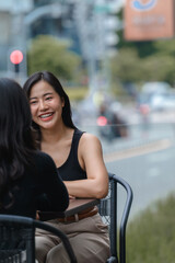 Two young businesswomen enjoying a coffee break together at an outdoor cafe