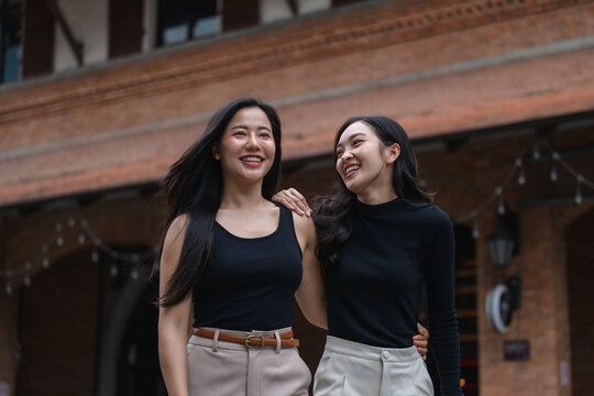 Two young businesswomen walking and talking in the city center - Powered by Adobe