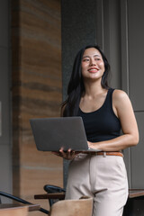 Young Asian Freelancer Working Remotely with Laptop in a Cafe