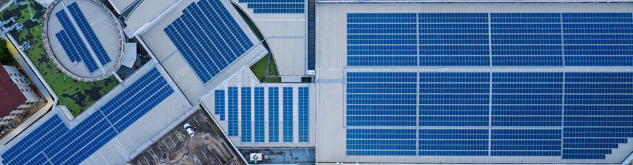 Obraz premium Solar roof, Solar on the roof, top view worker installing a solar cell on the factory roof, panels on tin roof seen from aerial view, panesl power.
