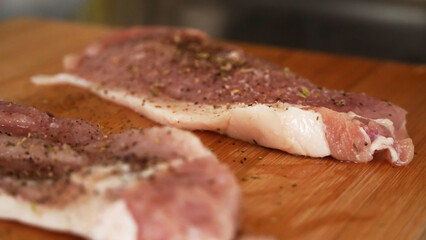 raw pork chops on a wooden board
