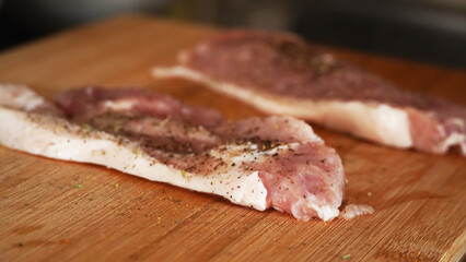 raw pork chops on a cutting board
