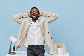 Confident smiling man with curly hair and beard wears light beige blazer, white shirt, poses happy...