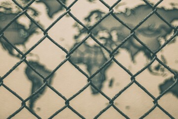 Fototapeta premium Global boundaries illustrated a world map behind a chain-link fence urban environment artistic perspective