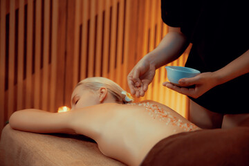 Woman customer having exfoliation treatment in luxury spa salon with warmth candle light ambient....