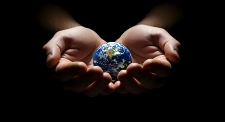 Gentle hands cradle the planet earth in a dark dramatic studio lighting