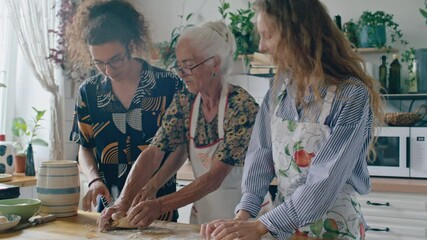 Young gen Z guy and his sister learning how to knead dough from elderly grandmother while cooking food together in cozy kitchen at home - Powered by Adobe