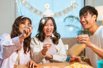 Asian birthday celebrate friends party. Happy birthday companionship enjoyment. Friendship emotion group laughing. Group friends partying birthday cake home. People playful anniversary. Friendship.