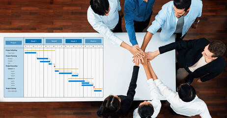 A diverse team collaborates on project management, showcasing a Gantt chart. The image captures...