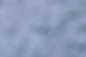 Abstract blurred background in shades of gray and light blue creating calm and soft atmosphere