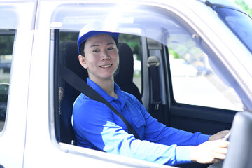 屋外で運転するアジア人男性の配送スタッフ