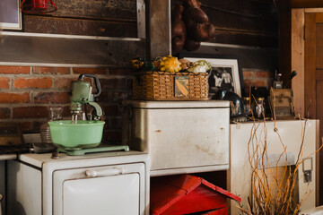 Rustic vintage kitchen interior with green stand mixer, retro appliances, brick wall, wicker...