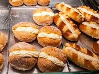 Golden custard-filled pastries on display in a San Sebastián bakery, showcasing artisanal baking, rich textures, and the sweet charm of traditional Spanish confections.