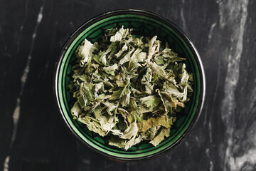 Dried mint leaves in bowl. Herbal tea ingredient. Aromatic natural remedy. Healthy traditional...