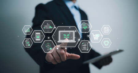 Businessman using eco-friendly digital interface with green tech icons for sustainability renewable energy carbon neutrality green e-commerce paperless solution recycling environmental responsibility