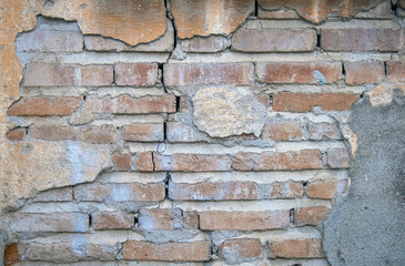 dirty brick wall with peeling plaster. old and dilapidated building. 