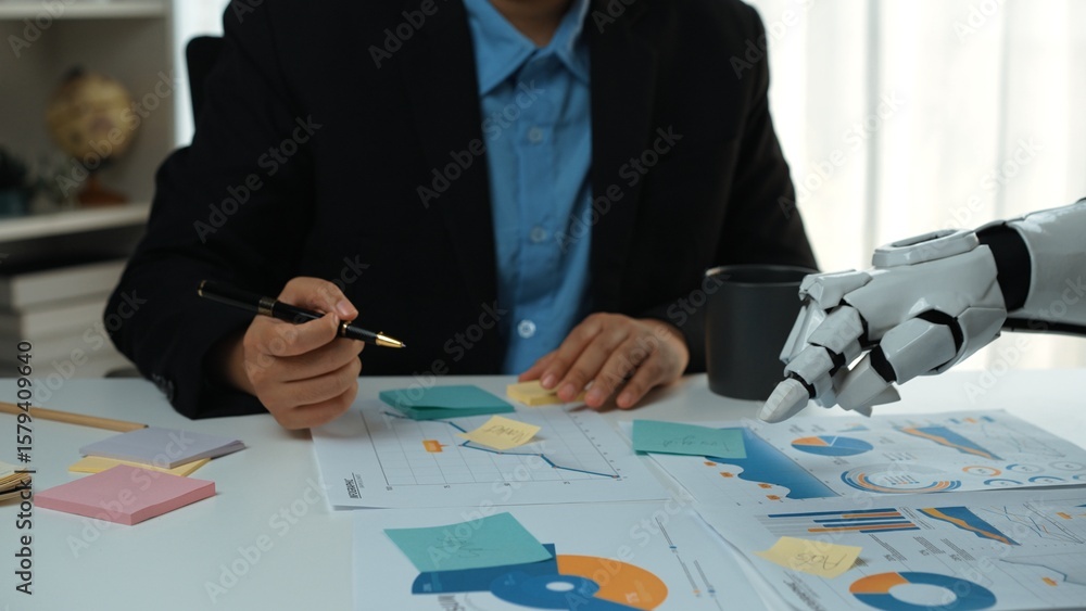 Poster a business professional collaborates with a robotic arm while analyzing data charts and graphs, high
