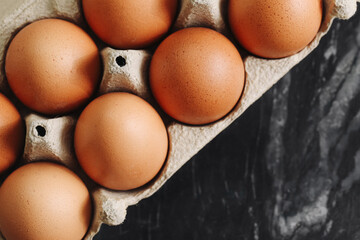 Brown chicken eggs in carton. Organic fresh eggs top view. Natural food product. Farm egg container...