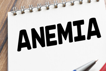 ANEMIA word in a notebook next to a stethoscope.