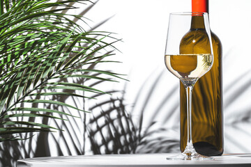 glass of white wine beside a bottle, with lush green plants creating an inviting atmosphere while...