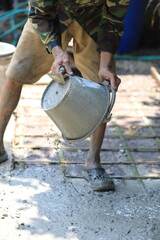 Cement pouring on steel rebar grid during construction, cement pouring close-up with wet texture in daylight, cement pouring on reinforced foundation floor