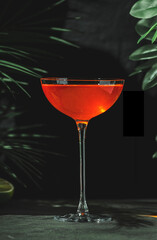 vibrant orange cocktail featuring mezcal, orange bitters, yellow liqueur, and fresh lime juice at a chic lounge