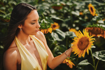 Fashion model posing in a sunflower field during a golden hour photo shoot