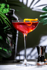 Delicious red cocktail with gin, vermouth, and herbal liqueur served in a stylish goblet at a...