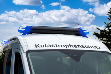 Flashing blue light and “Katastrophenschutz” lettering on emergency response vehicle.Disaster...