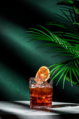Iced Caramel Coffee alcoholic cocktail drink with vodka, cold coffee, dry orange and ice. Green...