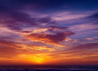 Fototapeta premium A beautiful sunset over the ocean with a colorful sky and the sun setting on the horizon.