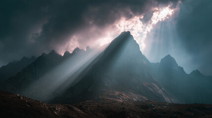 Sun rays breaking through clouds over rocky peaks