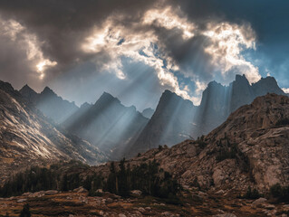 Sun rays breaking through clouds over rocky peaks