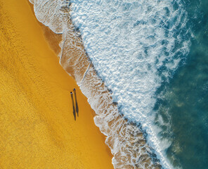 Aerial view of the beach with waves and sand. Bright ocean beach and water.