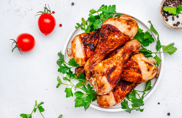 Baked chicken legs or drumsticks, white table background, top view