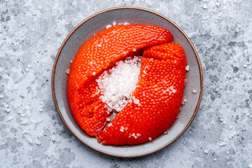 Fresh whole raw red caviar extracted from live trout or salmon with sea salt, grey background, top...
