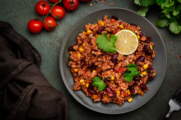 Mexican Chili dish with minced beef, beans, paprika, corn, cilantro, jalapeno pepper in tomato sauce, top view