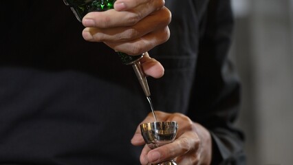 Closeup mixing hand bartender holding jigger to measure juice into shaker design preparation for...