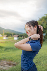 A woman in a blue shirt is standing in a grassy field