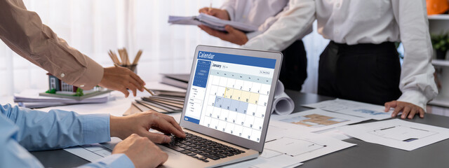 Group of interior architect designer discussing together on blueprint and laptop screen display...