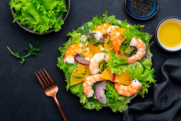 Gourmet shrimp salad with juicy orange, green lettuce, onion with olive oil and citrus juice...