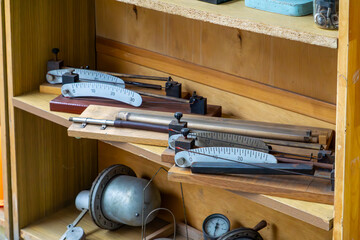 Vintage force gauges and manometers on a wooden shelf, old measuring instruments from a workshop or...