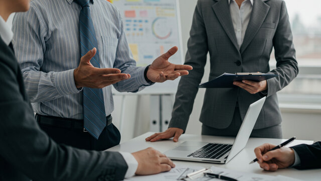 Business professionals in a strategic meeting, discussing data insights and planning future actions in a collaborative office setting.