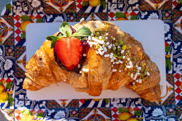 Italian breakfast, fresh baked butter croissant filled with ricotta cheese and jam, served outdoor...