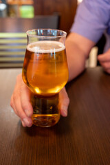 Freshly brewed light pils German beer in craft brewery served in beer glass poured from keg
