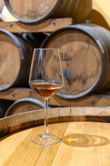 Visit of wine cellar with old large oak barrels, glass of fortified dry or sweet tasty marsala wine from barrels in Marsala, Sicily, Italy