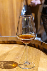 Visit of wine cellar with old large oak barrels, glass of fortified dry or sweet tasty marsala wine from barrels in Marsala, Sicily, Italy